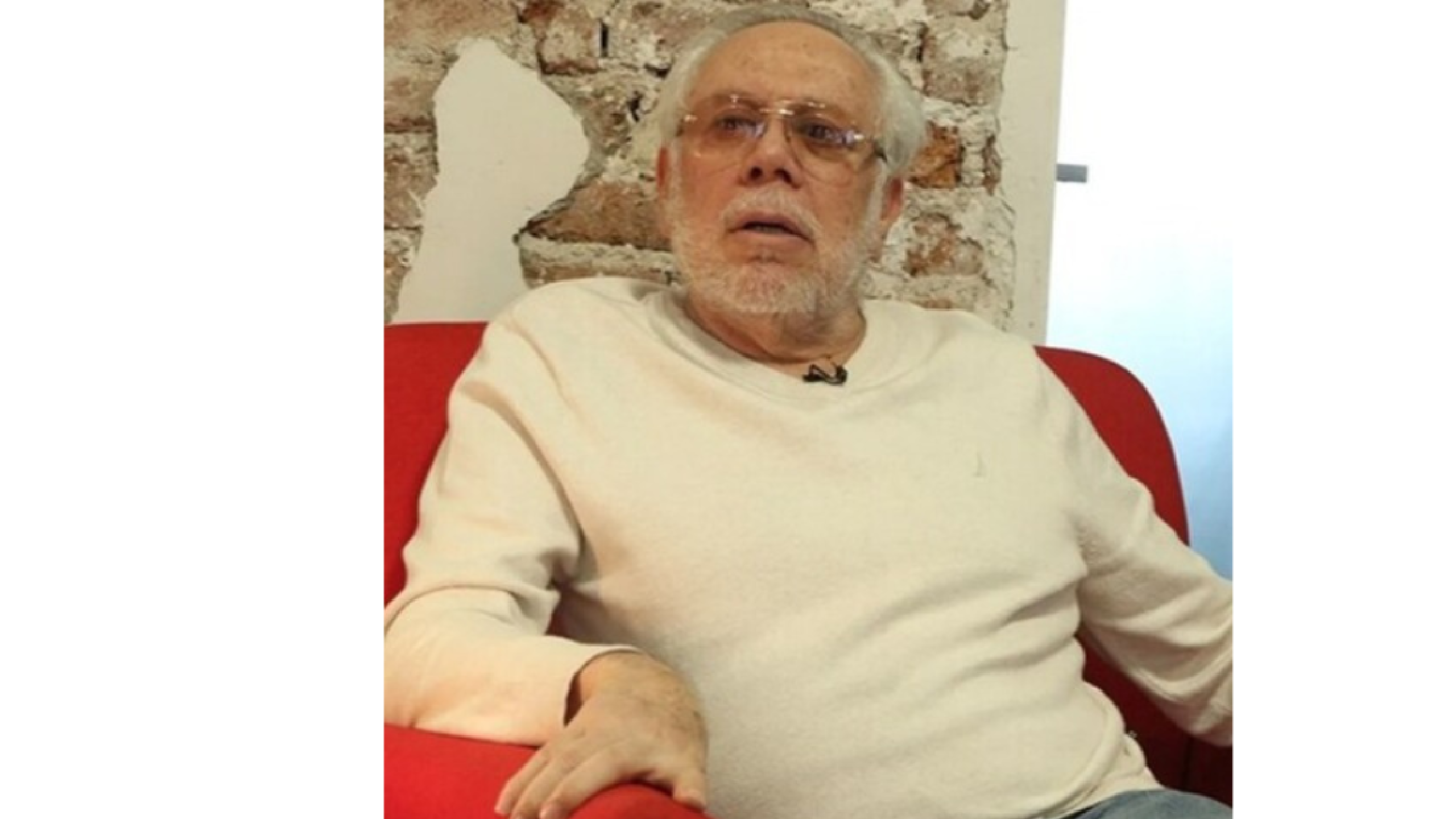 Luis de llano en plena entrevista sentando en un sillón rojo