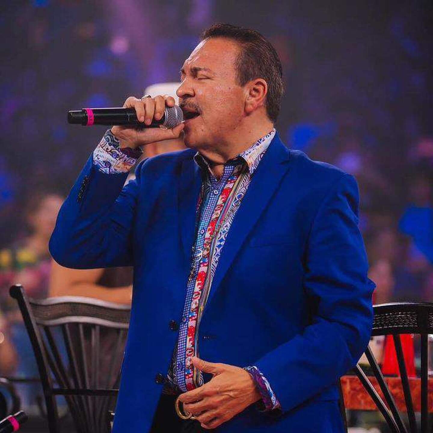 Julio Preciado cantando con traje azul