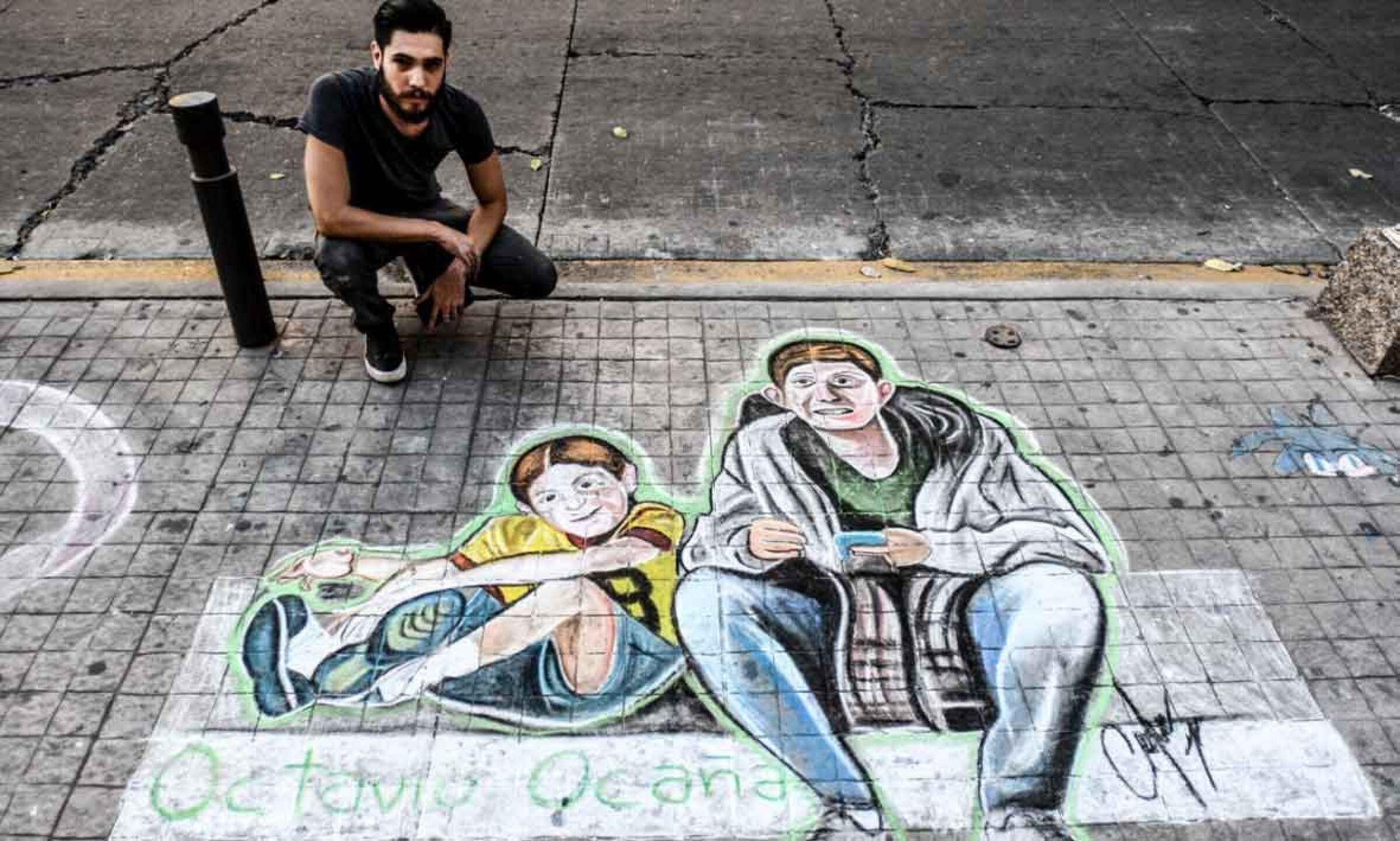 Artista pinta dibujo en la calle en honor a Octavio Ocaña.
