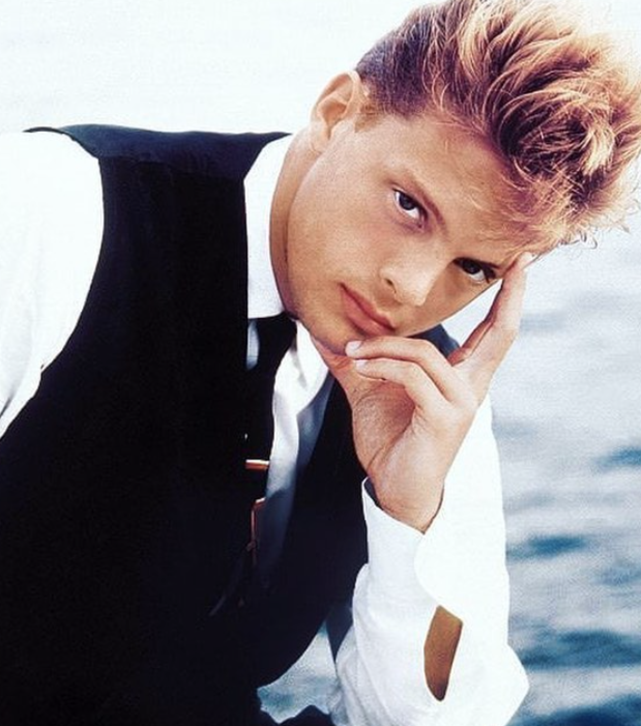 Luis Miguel de traje posando en su juventud de manera seria