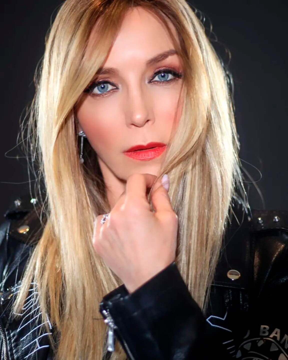 Laura Flores posando seria a la cámara con labios rojos